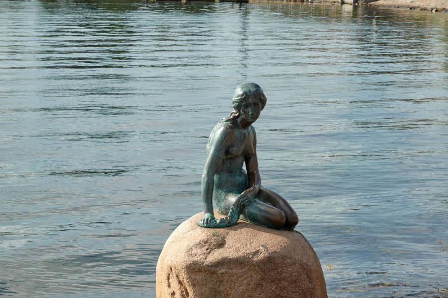 Statue der kleinen Meerjungfrau mit Wasser im Hintergrund