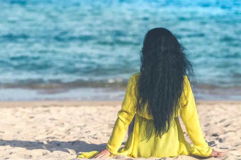 woman with long hair sitting on beach, what is the mermaid hair challenge